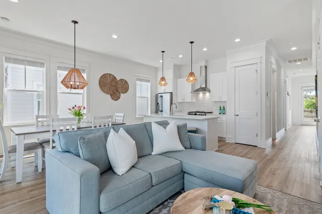 a living room with furniture kitchen and a chandelier