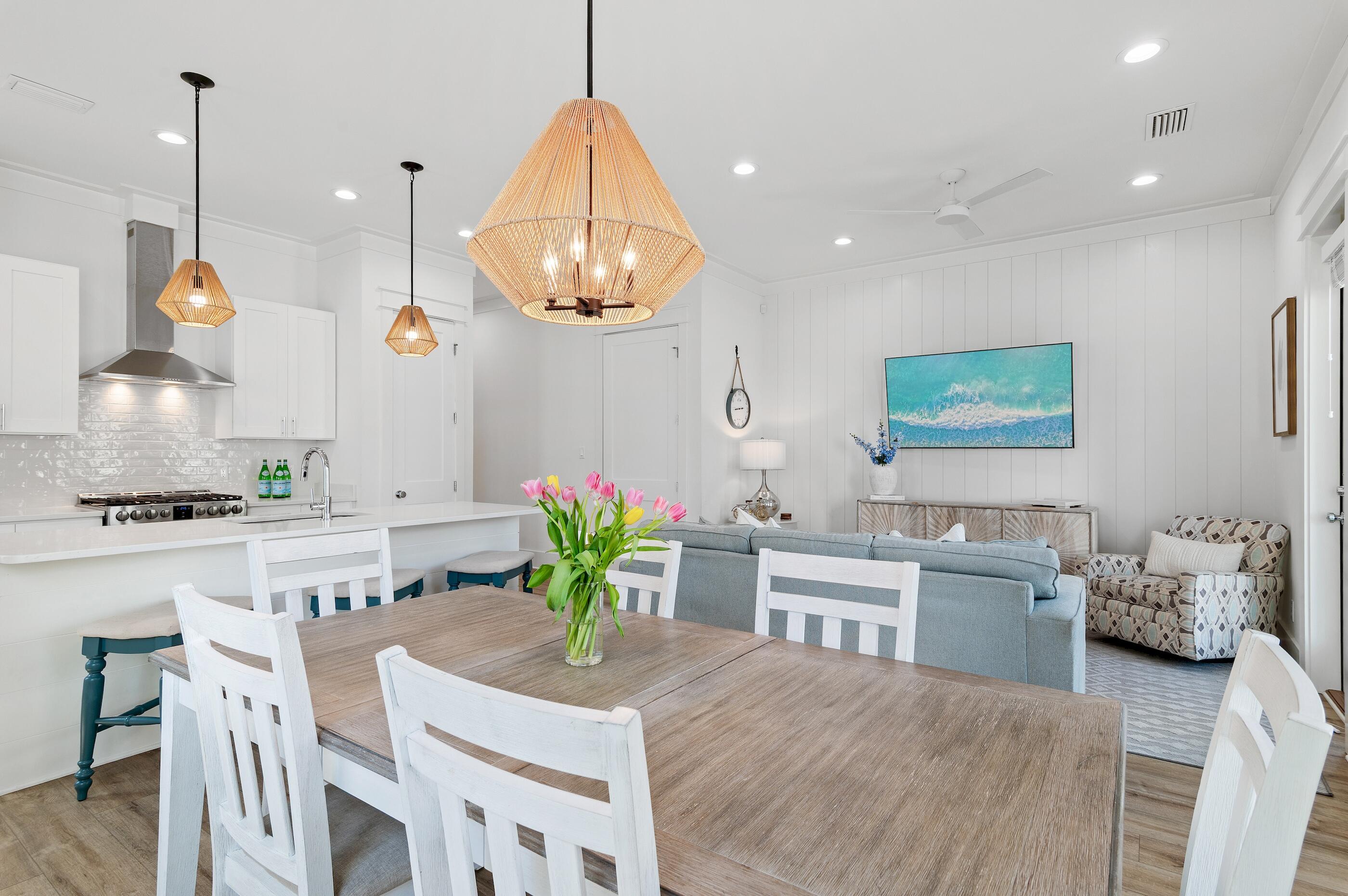 63 Sawgrass Lane Santa Rosa Beach, FL 32459 - Photo 7 of 51 a kitchen with stainless steel appliances a dining table chairs stove and white cabinets
