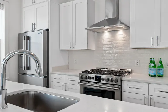 a kitchen with stainless steel appliances granite countertop a sink stove and cabinets