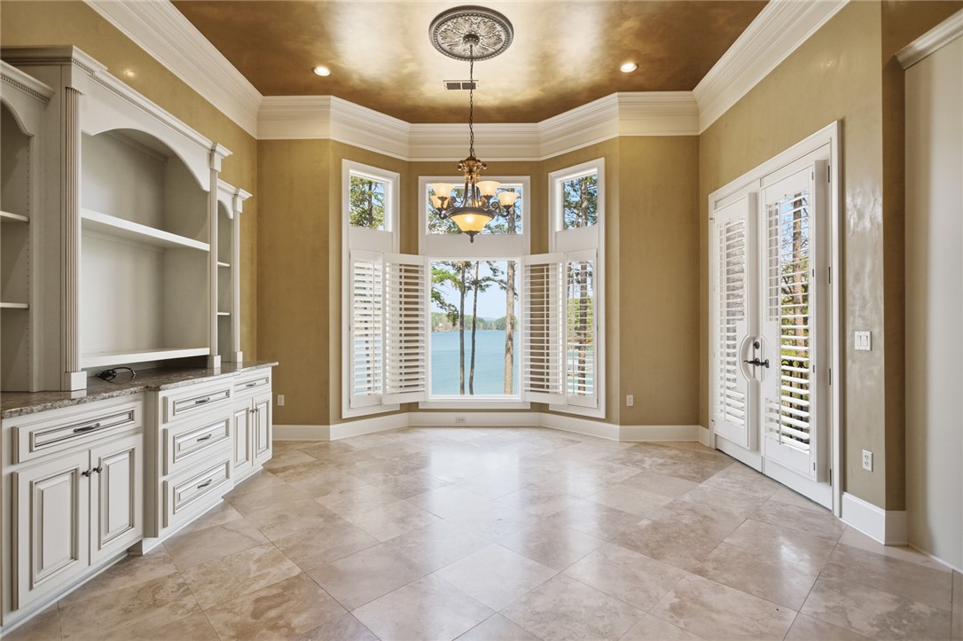 610 Highridge Drive Seneca, SC 29672 - Photo 19 of 50 This bright space features built-in shelving, elegant crown molding, and expansive windows showcasing beautiful lake views.