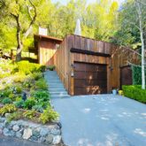a view of a house with a yard and potted plants