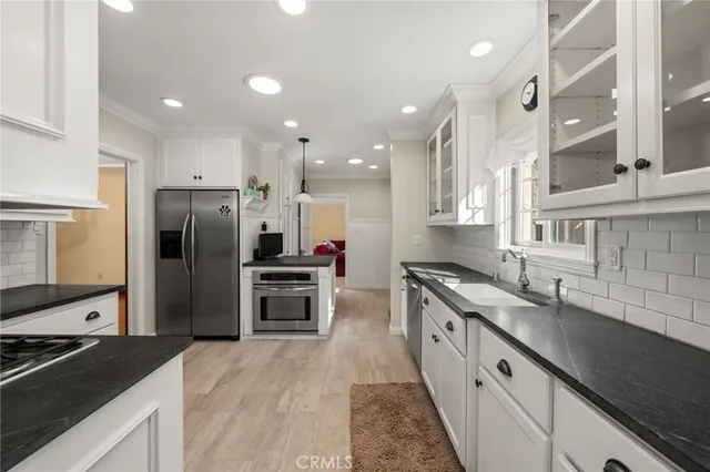 a kitchen with stainless steel appliances granite countertop a sink stove and refrigerator