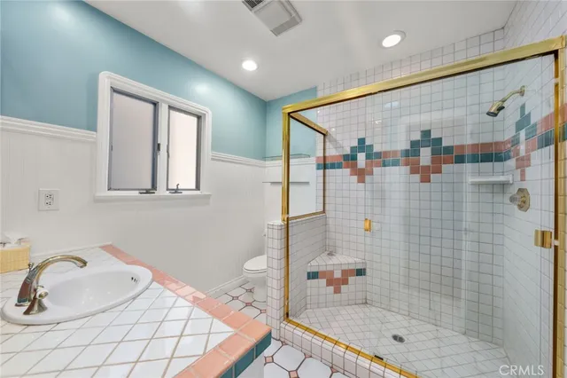 a bathroom with a shower sink and mirror