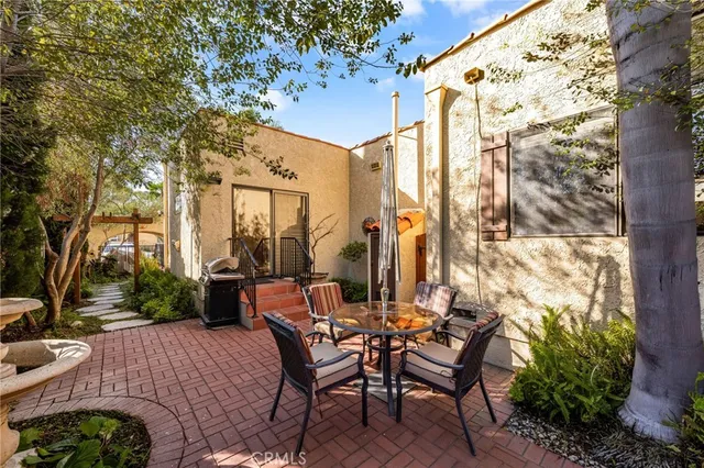 a view of a patio with table and chairs and potted plants