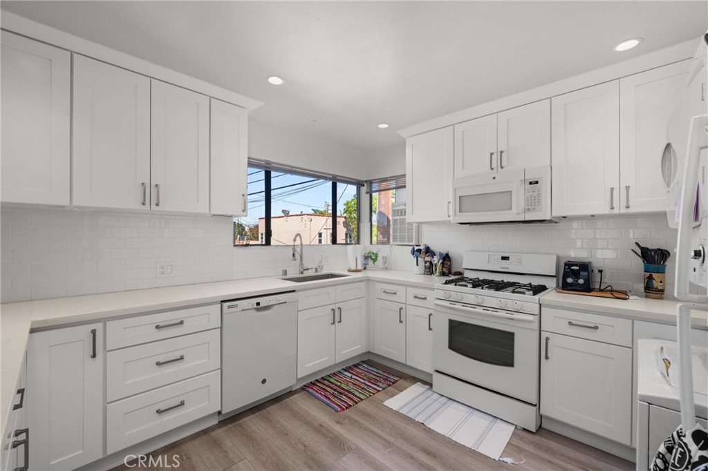 3754 California Long Beach, CA 90807 - Photo 27 of 38 a kitchen with cabinets stainless steel appliances a sink and wooden floor