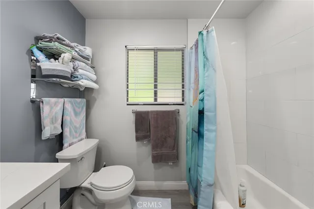 a bathroom with a toilet a sink and a window