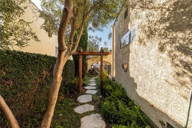 a view of a house with a small yard and potted plants