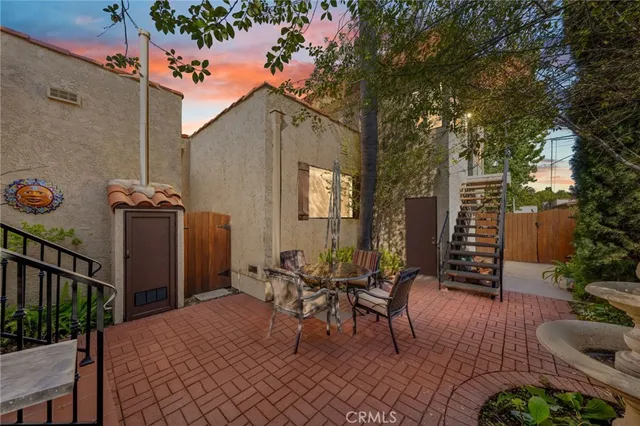 a view of a patio with couches table and chairs and potted plants