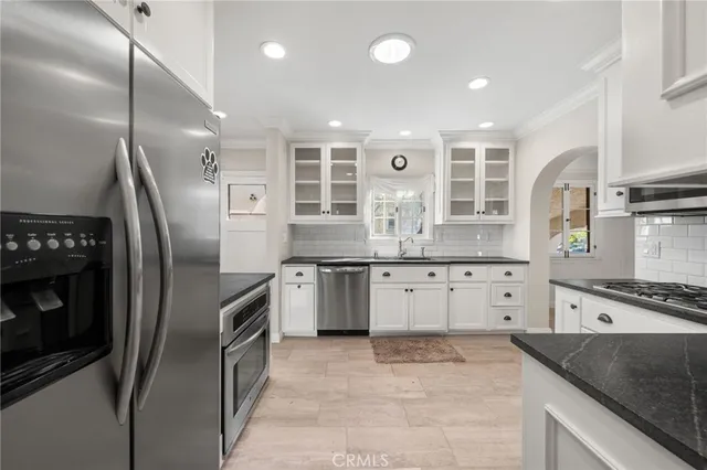 a kitchen with stainless steel appliances granite countertop a stove a sink and a refrigerator