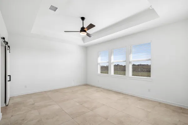 an empty room that has a window and kitchen view