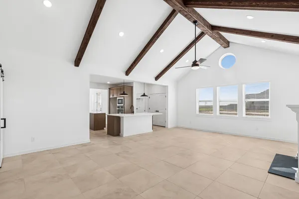 an empty room with windows and ceiling fan