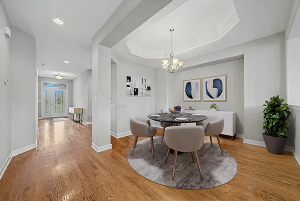 a view of a dining room with furniture a chandelier and wooden floor