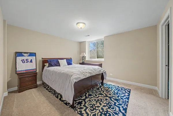 a bedroom with a bed and a dresser with wooden floor