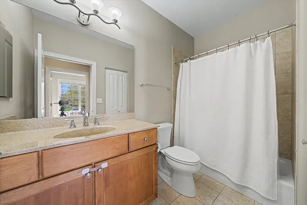 a bathroom with a sink a toilet a mirror a vanity and shower