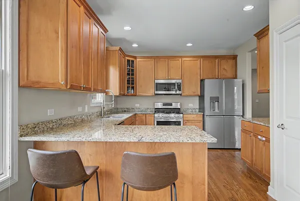 a kitchen with stainless steel appliances granite countertop a refrigerator a stove a sink dishwasher with a dining table and chairs