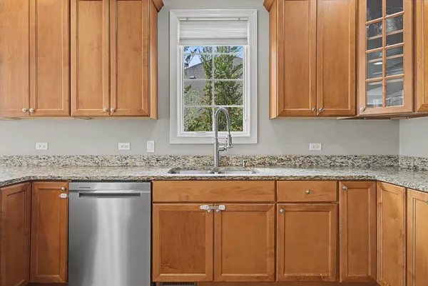 a kitchen with granite countertop cabinets sink and window