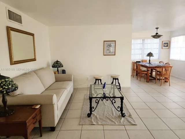 a living room with furniture and a dining table