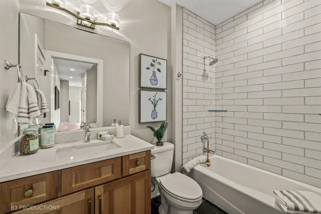 a bathroom with a bathtub shower sink mirror vanity and toilet