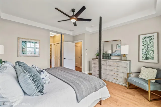a bedroom with a bed chandelier and a window
