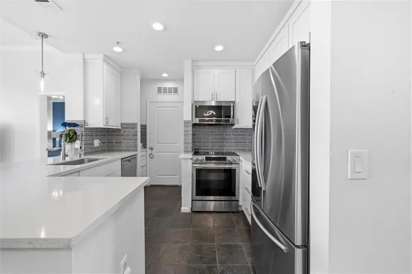 a kitchen with stainless steel appliances a refrigerator sink and cabinets