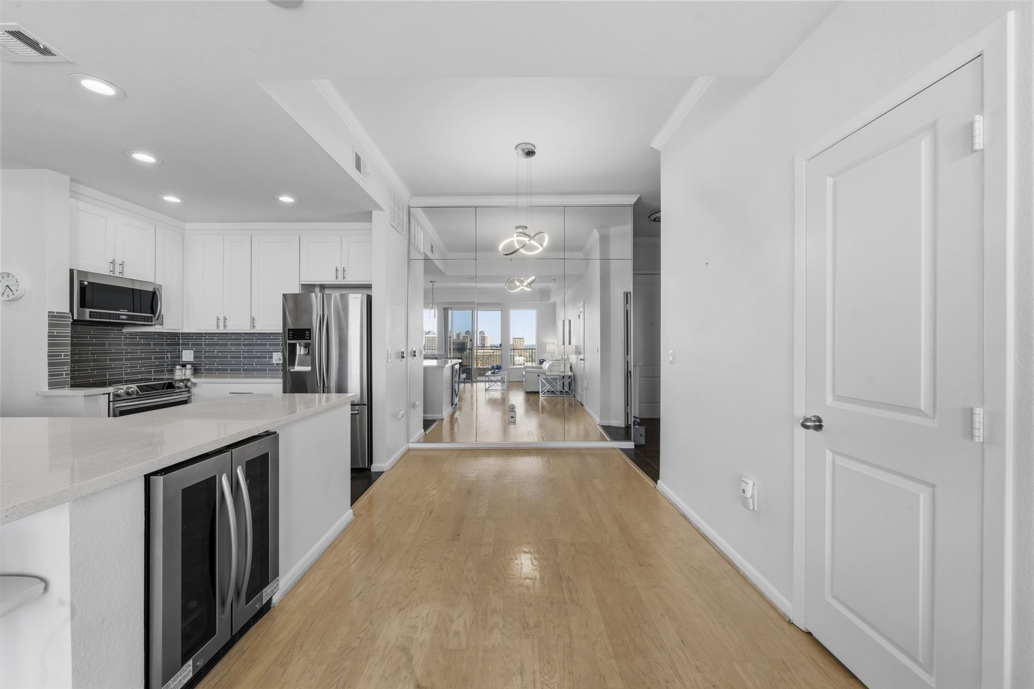 3505 Sage Road, Unit 1905 Houston, TX 77056 - Photo 6 of 15 a view of a kitchen with kitchen island a sink wooden floor and stainless steel appliances
