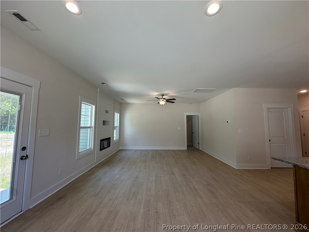 2908 Calloway Road Raeford, NC 28376 - Photo 12 of 25 an empty room with wooden floor chandelier and windows