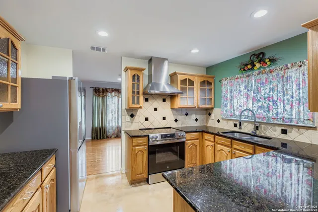 a kitchen with stainless steel appliances granite countertop a stove and a refrigerator