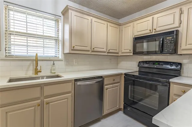 a kitchen with stainless steel appliances granite countertop a sink and a stove