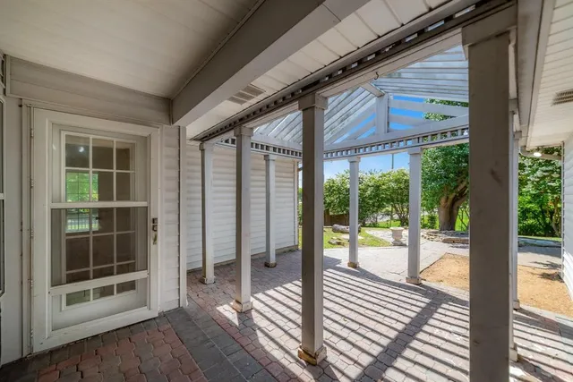 a view of a balcony with furniture and umbrella
