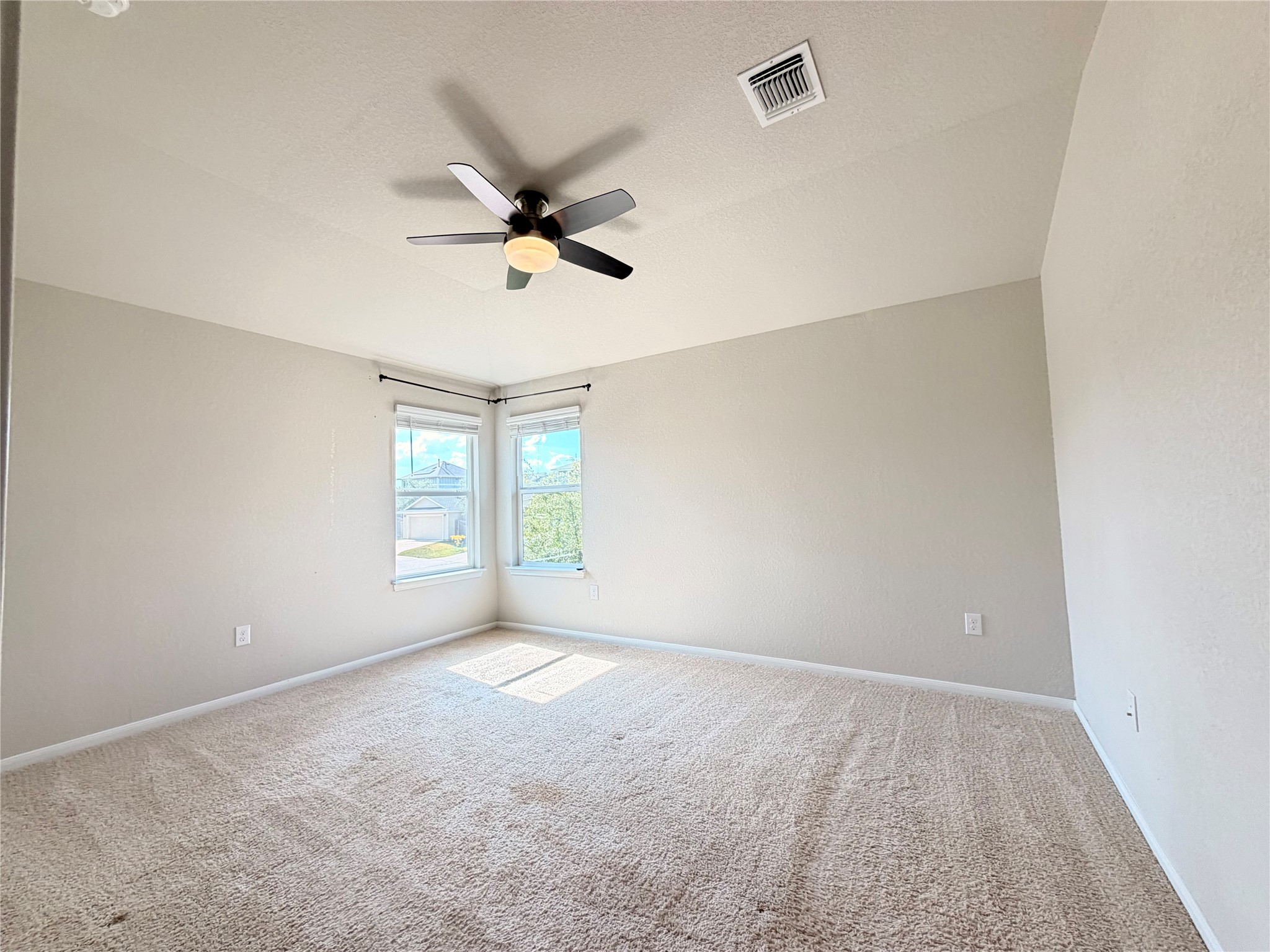 10502 Fulton Avenue Austin, TX 78754 - Photo 17 of 36 Sun-filled windows illuminate the spacious room with cozy carpeting, ready for personalized touches.
