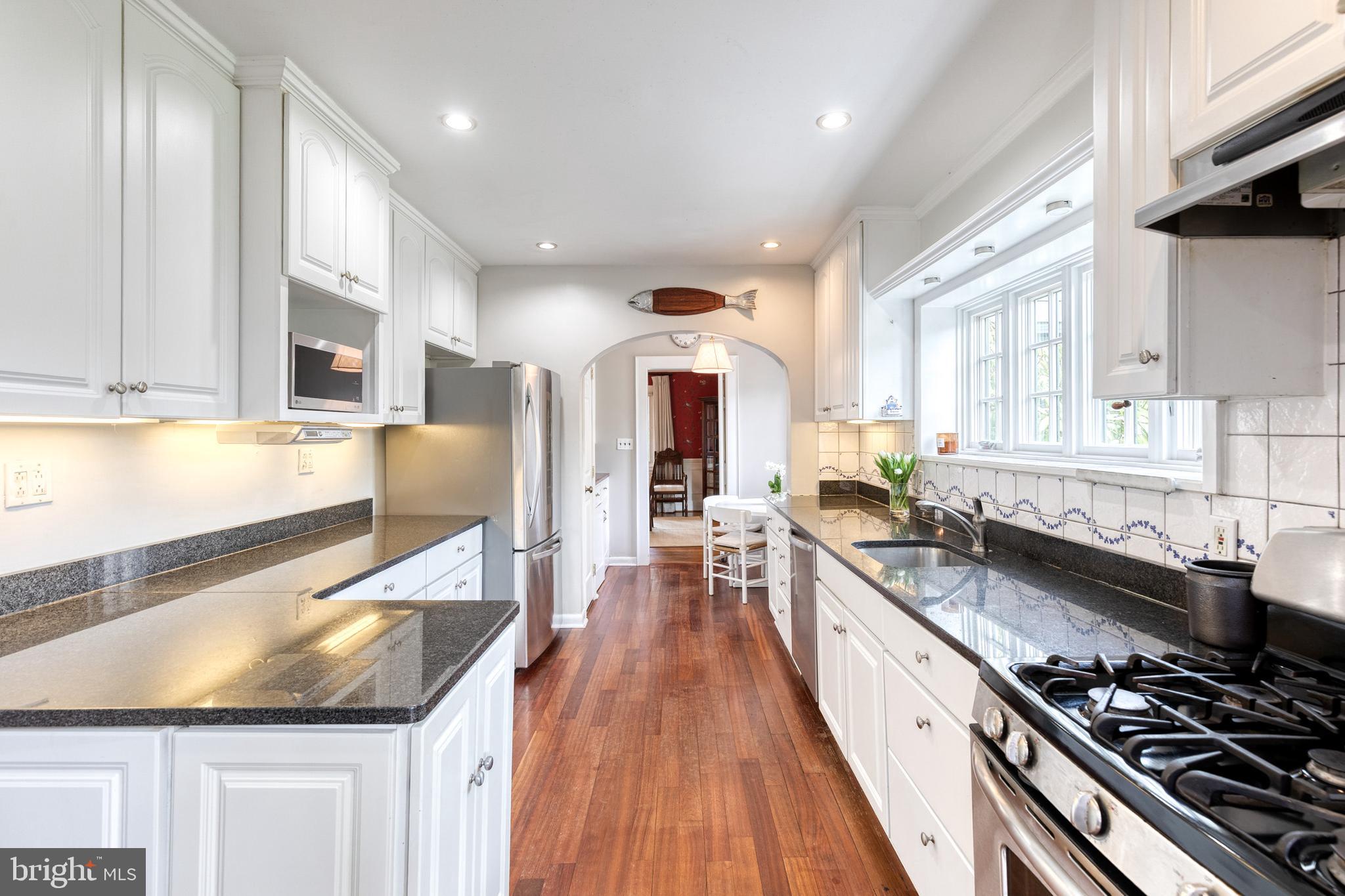 202 Taplow Road Baltimore, MD 21212 - Photo 13 of 56 a large kitchen with stainless steel appliances granite countertop a stove and a large window