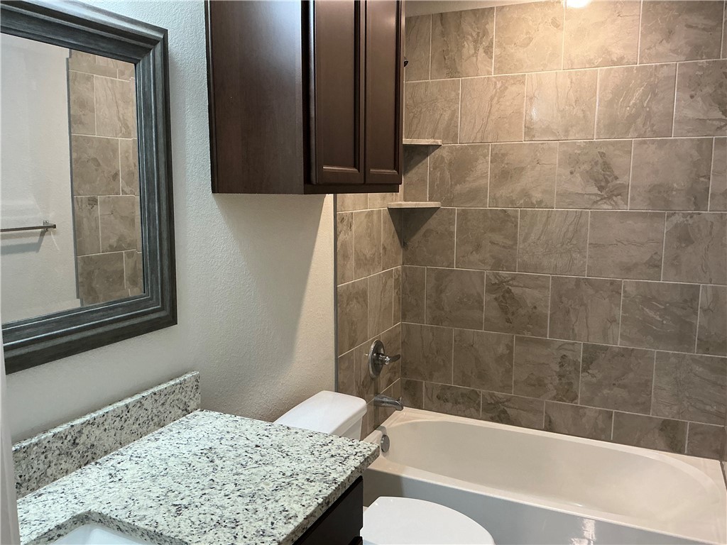 3896 Still Creek Loop College Station, TX 77845 - Photo 14 of 19 a bathroom with a granite countertop bathtub shower and toilet