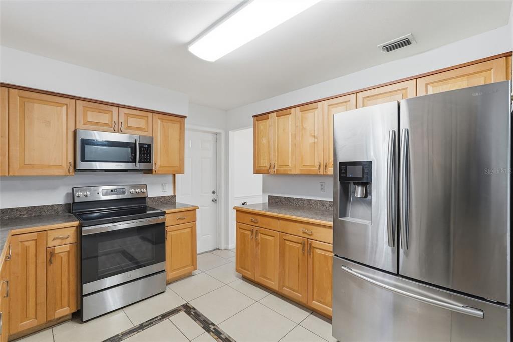 4848 Judy Ann Court Orlando, FL 32808 - Photo 11 of 39 a kitchen with stainless steel appliances granite countertop a refrigerator stove and sink