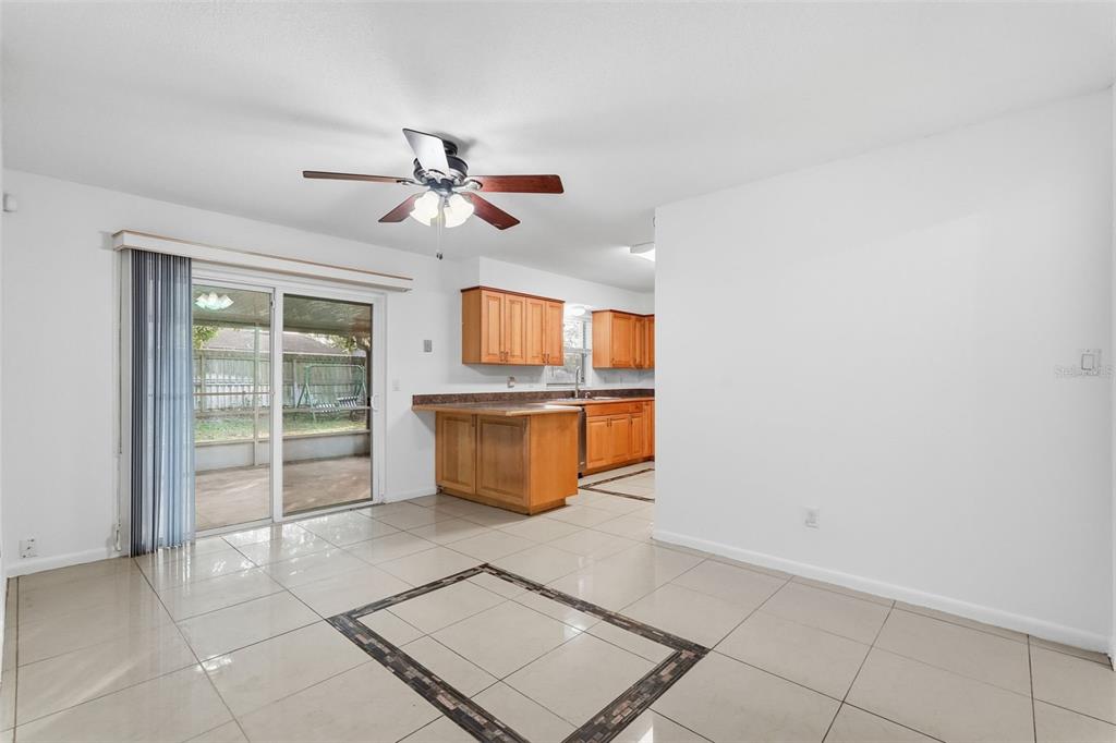4848 Judy Ann Court Orlando, FL 32808 - Photo 13 of 39 a view of a kitchen with wooden cabinet and a ceiling fan