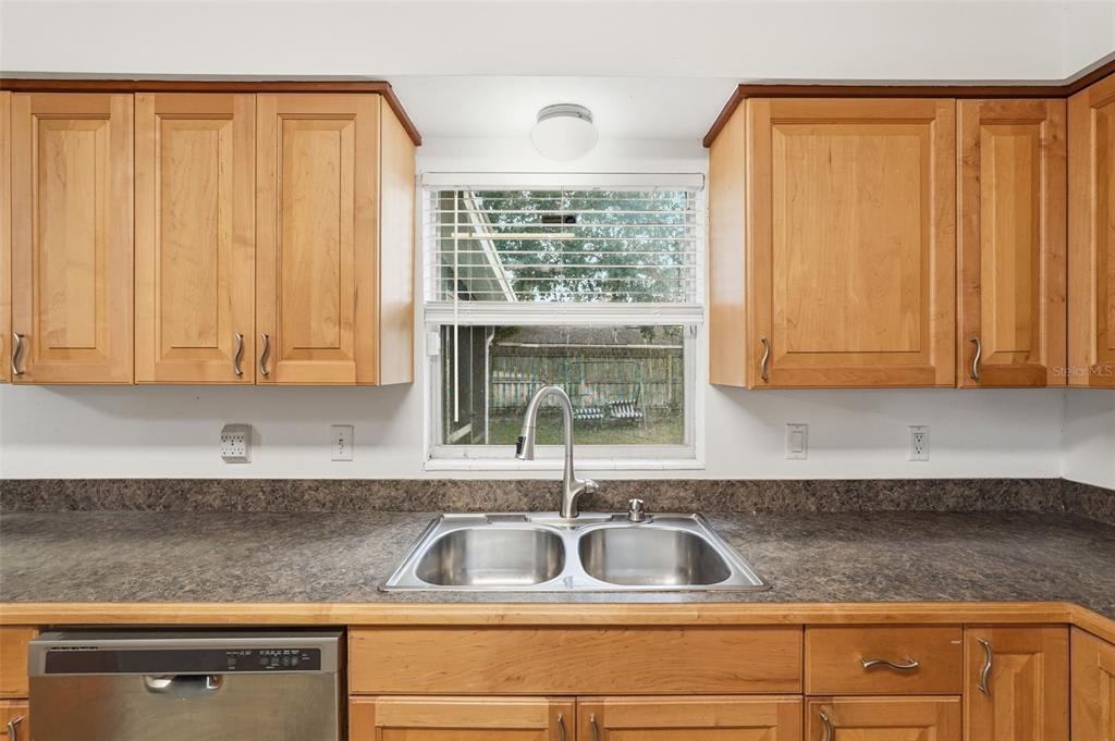 4848 Judy Ann Court Orlando, FL 32808 - Photo 9 of 39 a kitchen with granite countertop a sink window and cabinets