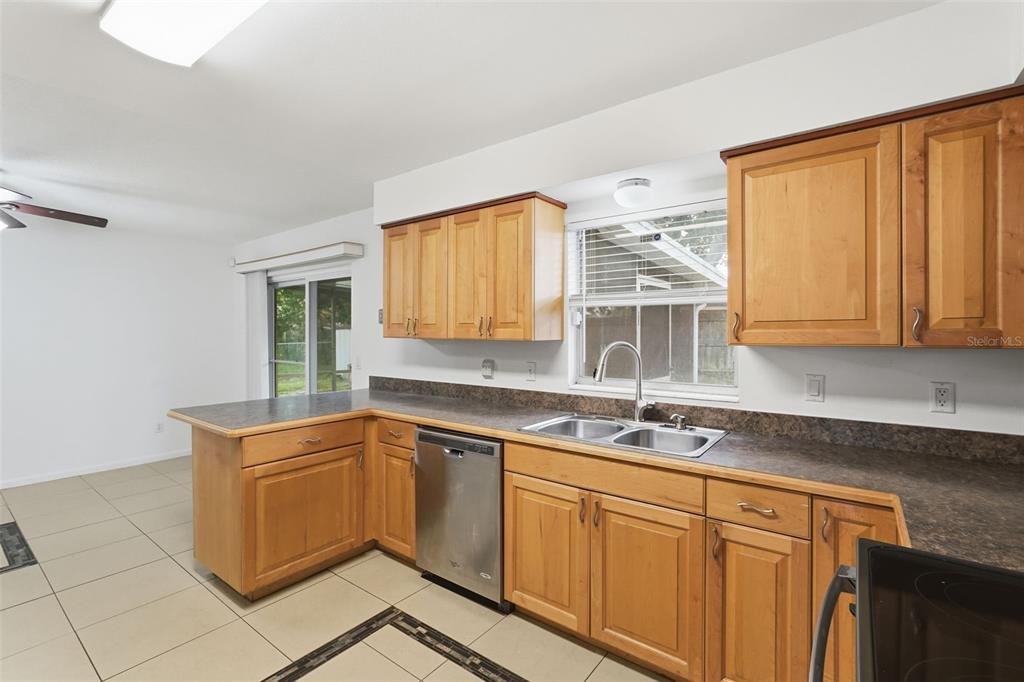 4848 Judy Ann Court Orlando, FL 32808 - Photo 10 of 39 a kitchen with stainless steel appliances granite countertop a sink stove and cabinets