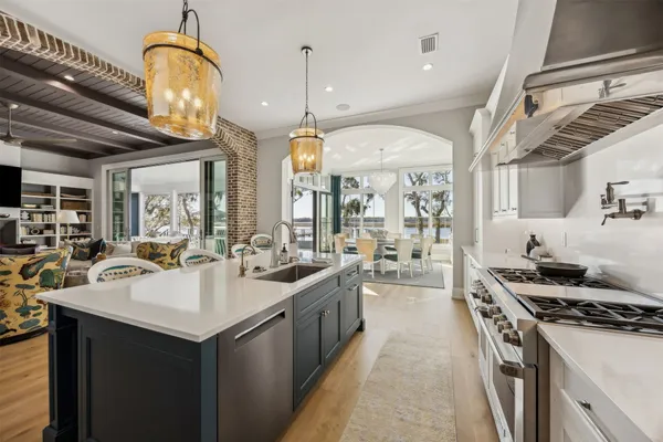 a view of a dining room with furniture a chandelier and large windows