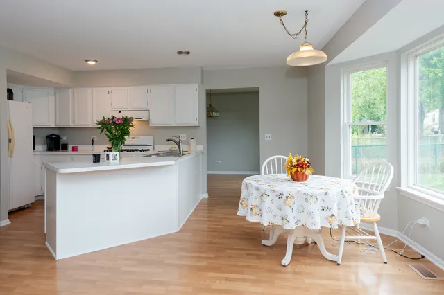 a kitchen with a table chairs sink and cabinets