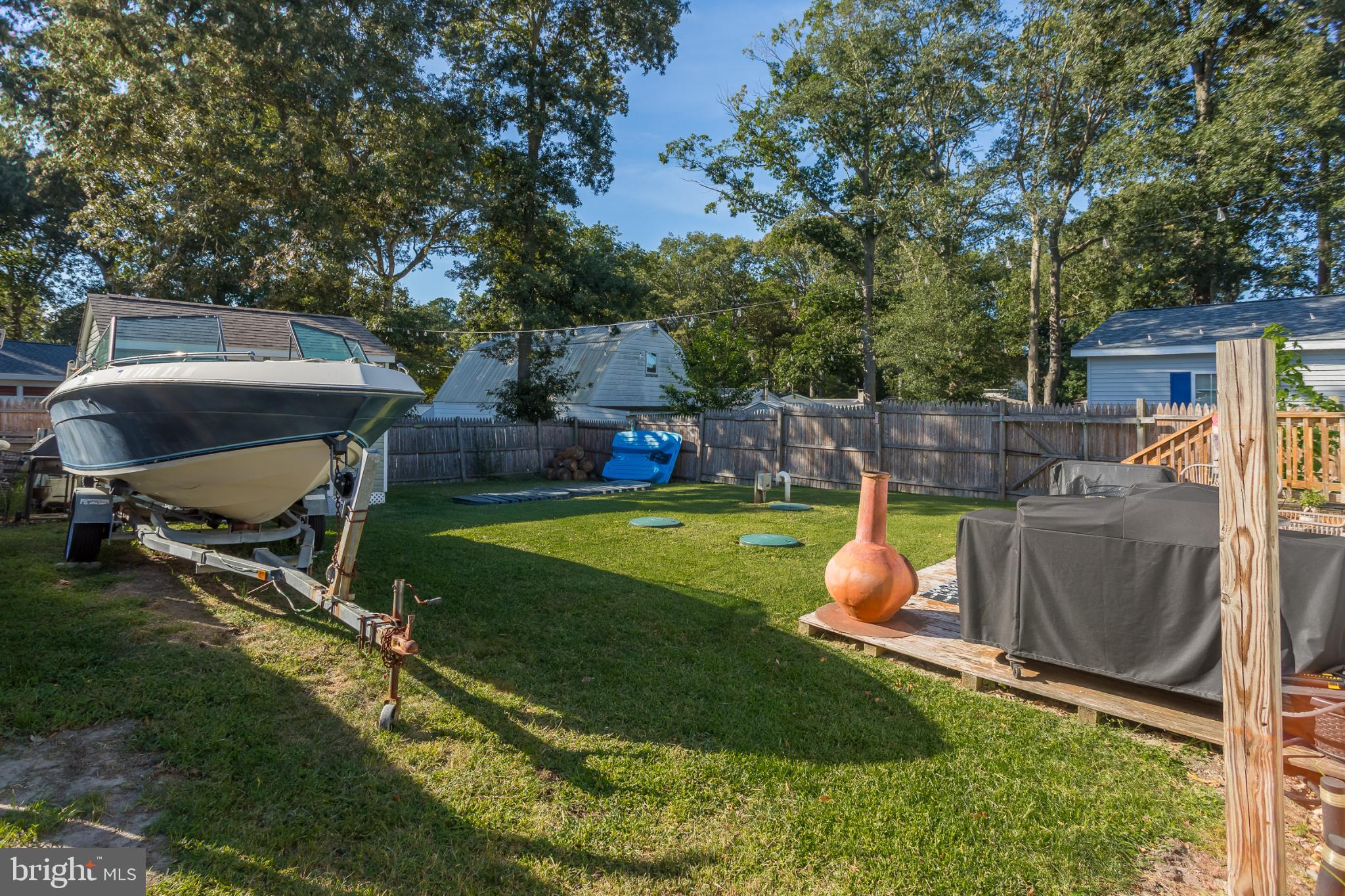 30837 West Lagoon Road Dagsboro, DE 19939 - Photo 21 of 36 Serene backyard with boat and greenery.