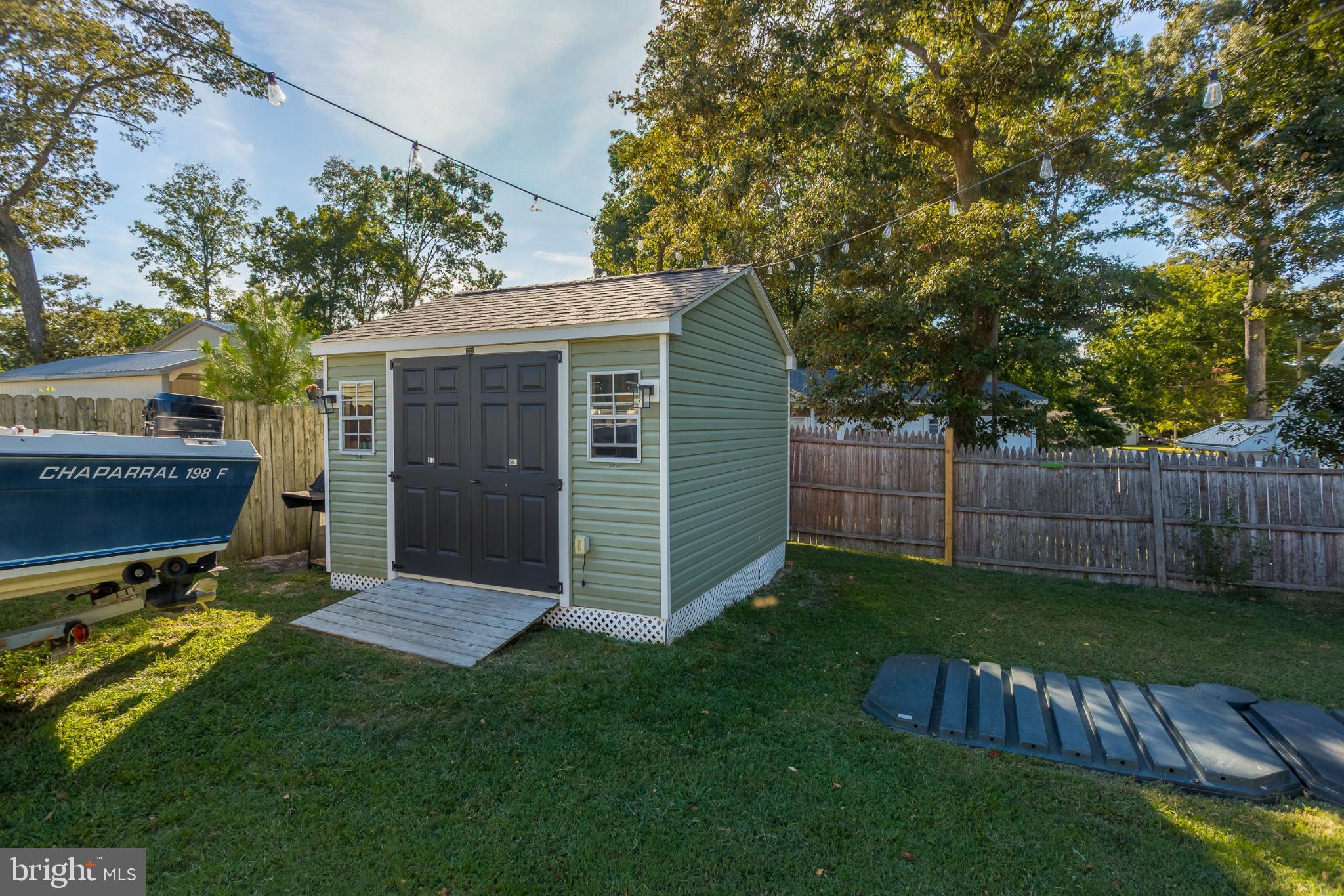 30837 West Lagoon Road Dagsboro, DE 19939 - Photo 22 of 36 Charming backyard shed with lush greenery.