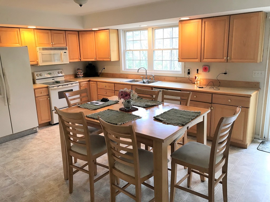 380 Richardson Road Dracut, MA 01826 - Photo 6 of 21 a kitchen with a table chairs sink refrigerator and microwave