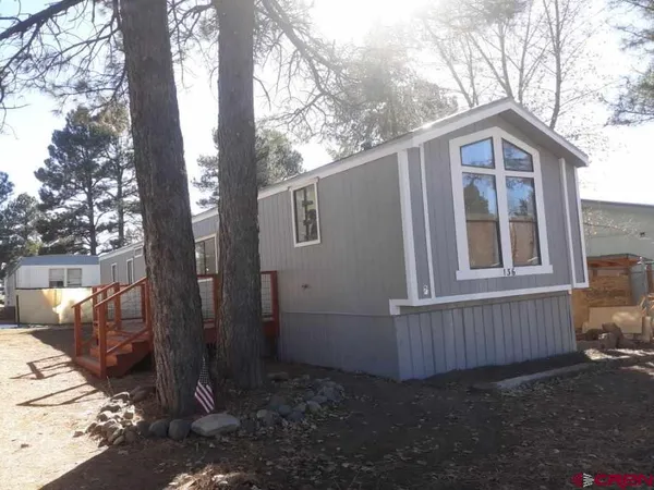 a view of backyard with deck and wooden fence