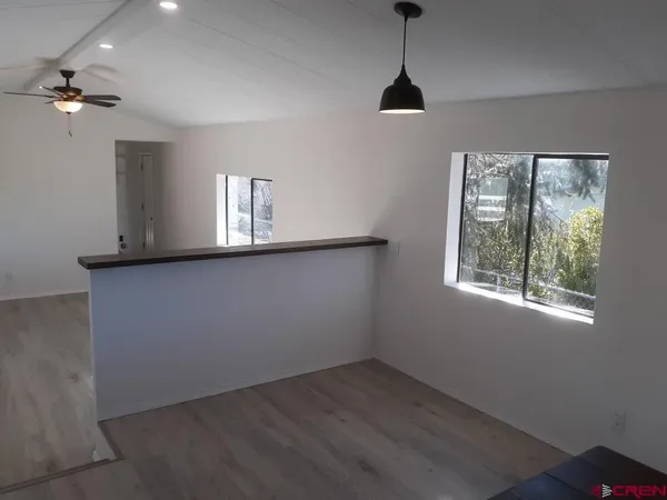 a view of a room with a window and wooden floor