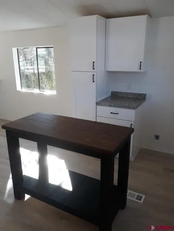 a kitchen with a stove and white cabinets