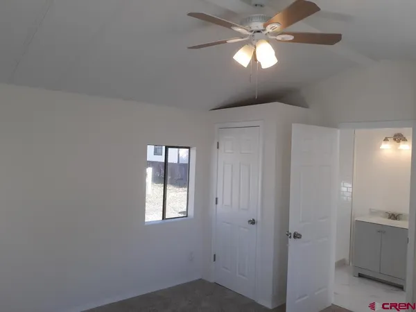 a view of empty room with window and ceiling fan