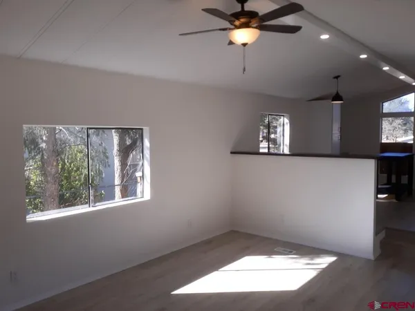 an empty room with windows and fan