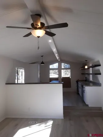 a kitchen with a chandelier stainless steel appliances cabinets and a window