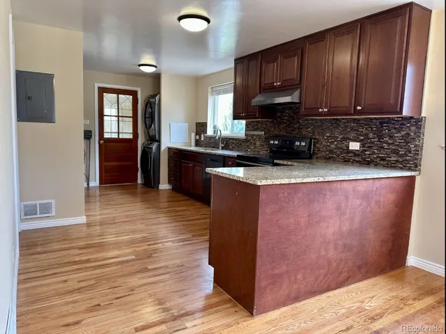 a kitchen with wooden floors and wooden cabinets