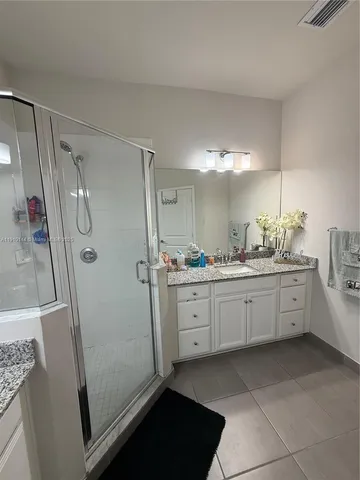 a bathroom with a double vanity sink a mirror a bathtub and shower