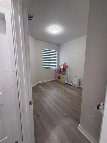 a room with wooden floor and window